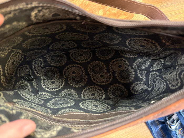 Leather handbag interior with dark paisley lining and visible top opening