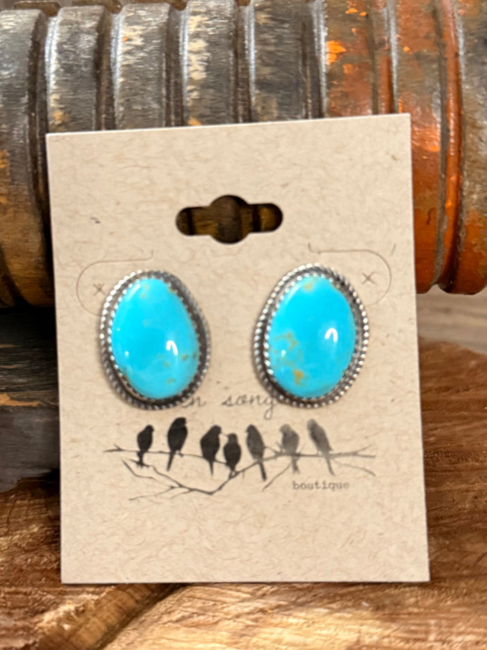Turquoise teardrop stud earrings with silver-tone beaded rim, on display card