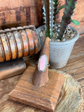 Sterling silver ring with oval pink conch shell center and textured bezel, size 7