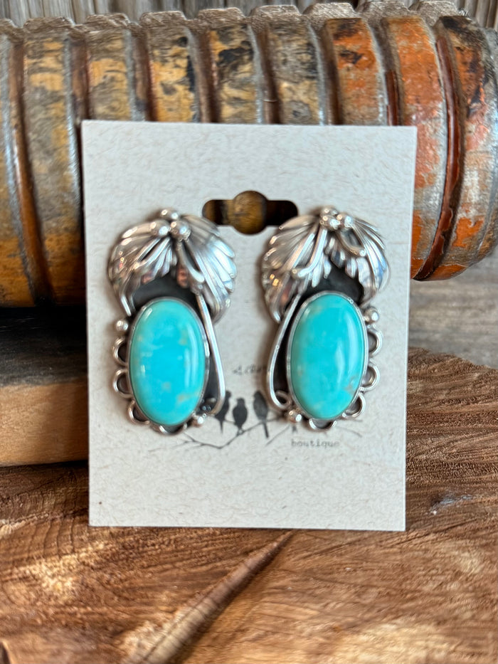 Sterling silver feathered stud earrings with turquoise oval dangles, front view