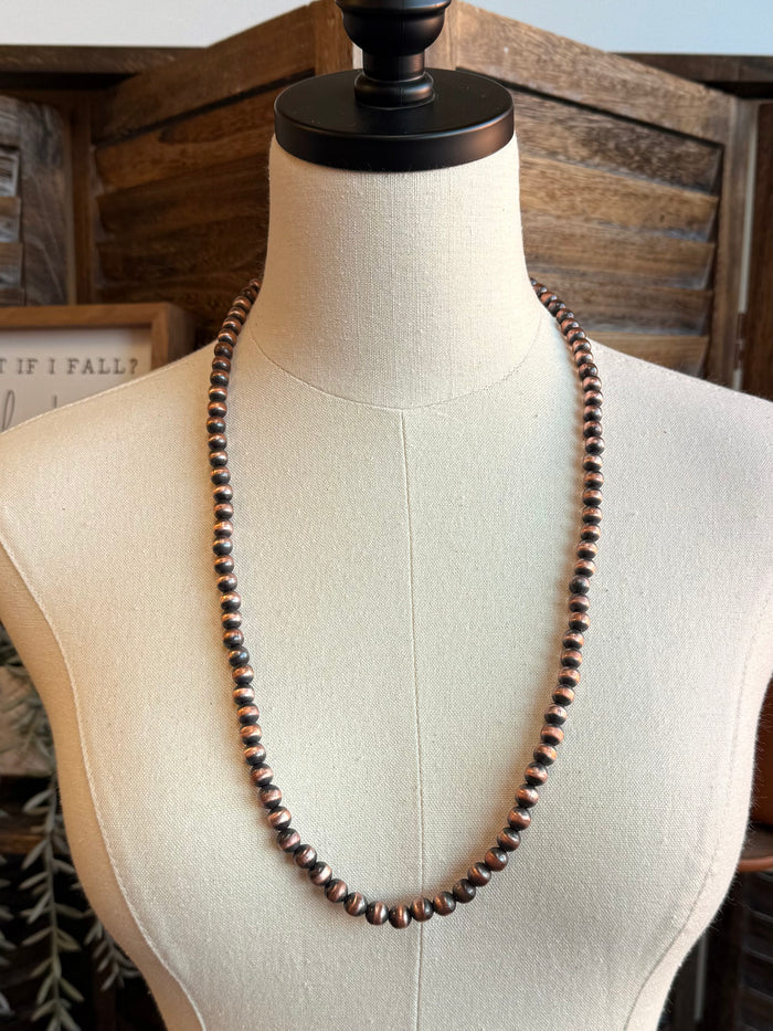 Copper bead necklace with uniform round beads, shown on mannequin