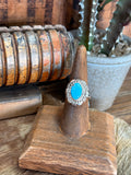 Sterling silver ring with oval turquoise cabochon and engraved halo detail