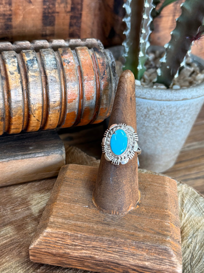 Sterling silver ring with oval turquoise cabochon and engraved halo detail