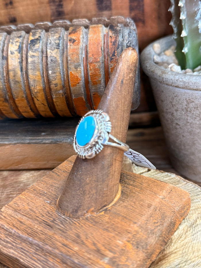 Sterling silver ring with bright turquoise oval stone and rope-style border