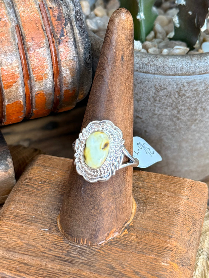 Sterling silver ring with ornate oval bezel and pale yellow stone, side view