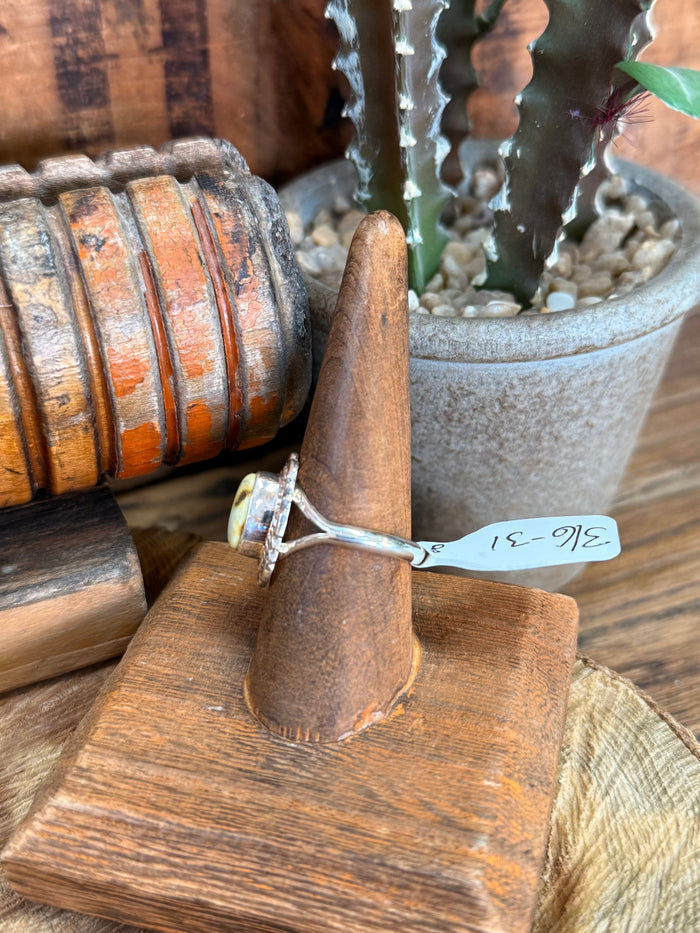 Sterling silver ring with oval stone set in an openwork band, side angle