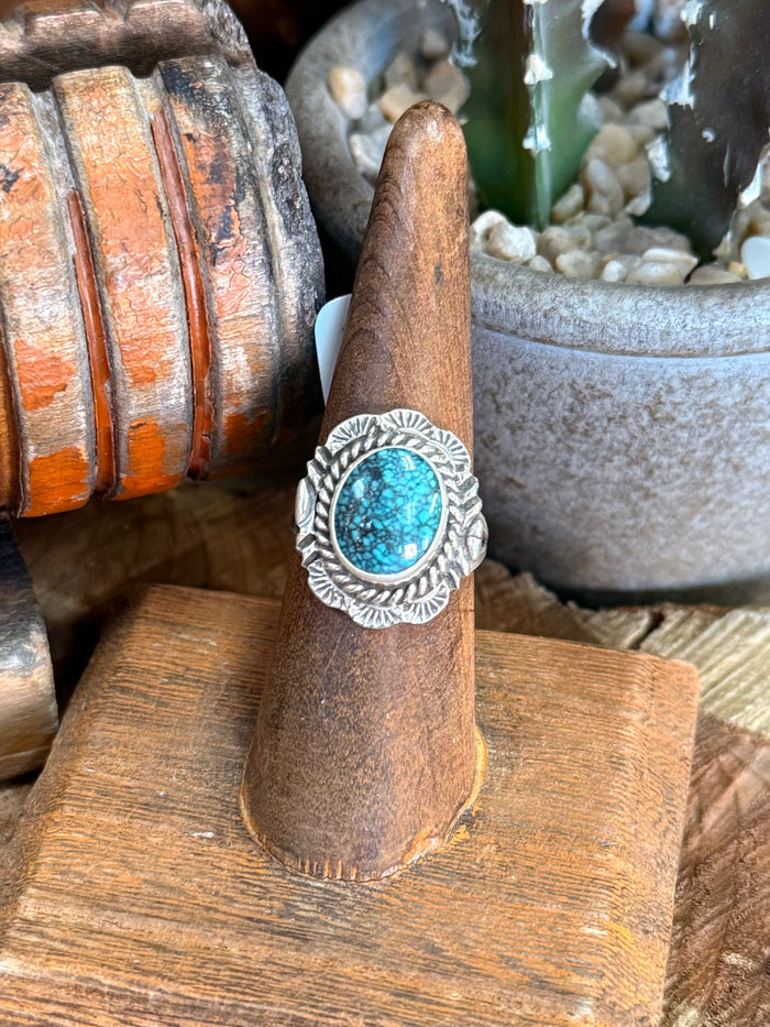 Turquoise oval sterling silver ring with decorative scroll edge, detailed band