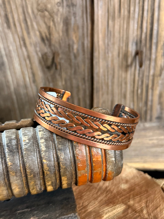 Woven copper cuff bracelet with braided strip pattern and open curved design