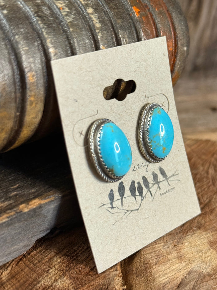 Turquoise teardrop stud earrings with silver-tone scalloped bezel and posts