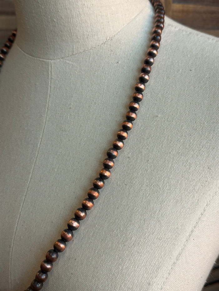 Close-up of copper round beads on a dark beaded necklace