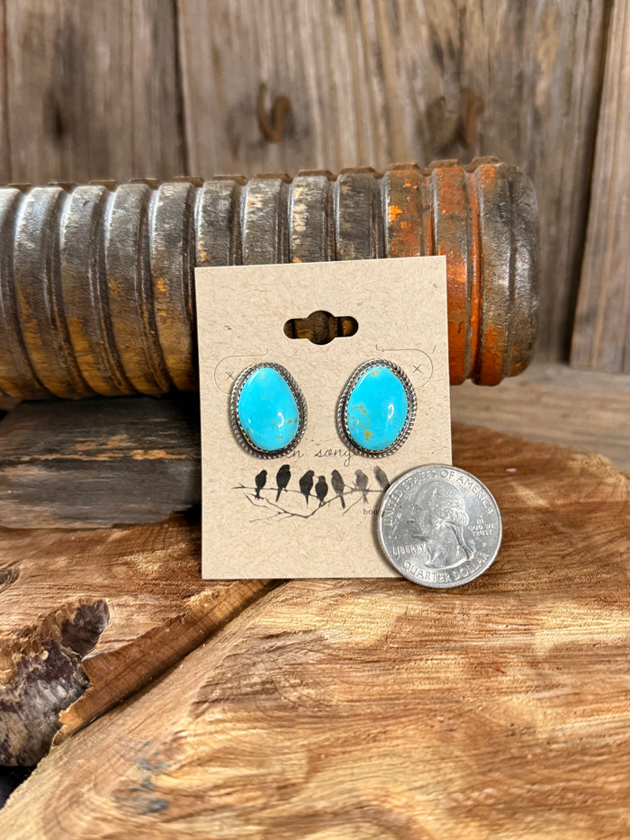 Turquoise teardrop stud earrings shown with coin for size comparison