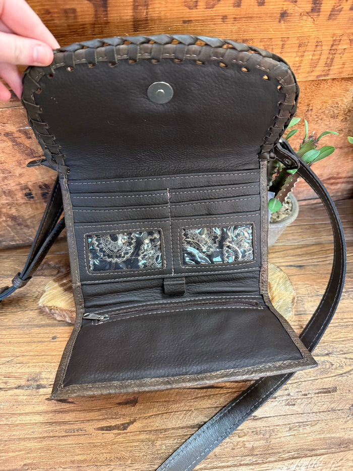 Dark brown crossbody purse interior with stitched pockets and turquoise-look trim