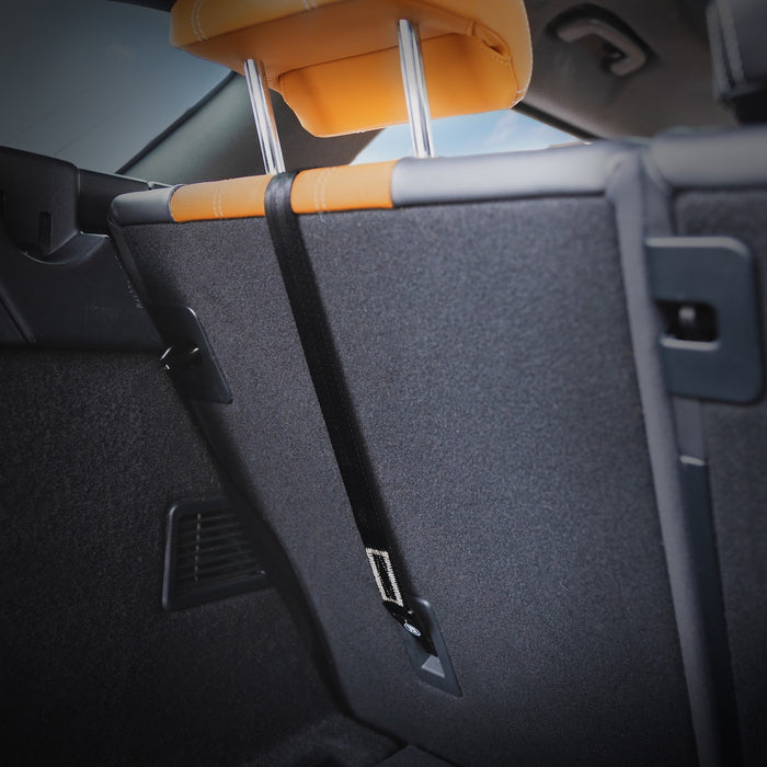 Car interior with orange headrest and black headliner.