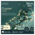 The Cluster LED 768 ct. String Lights Warm White by Available for Pickup & Delivery features a 20 ft strand with 768 warm white LEDs, shown illuminated against a teal background—ideal for holiday displays.