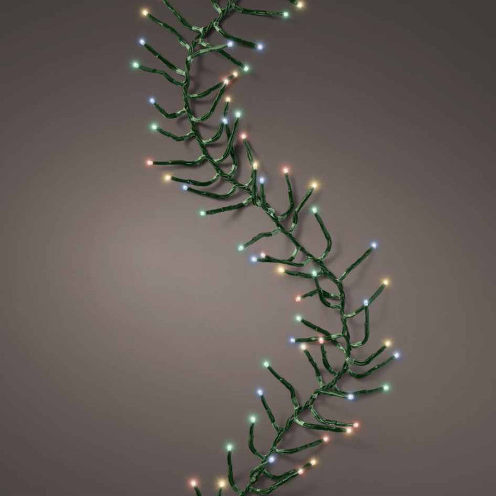 The Cluster Twinkle LED 500 ct. String Lights Multi-Colored by Available for Pickup & Delivery are displayed in a loose, wavy line with a green wire against a plain gray background.