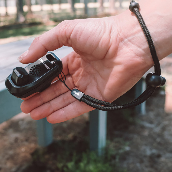 a person holding a hands-free dog training clicker