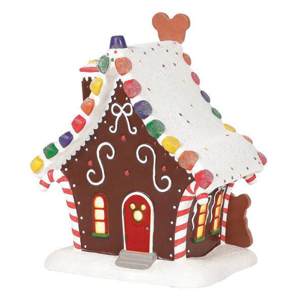 The Department 56 - Mickey’s Gingerbread House features festive Mickey-themed Christmas décor, white icing, colorful candy pieces, peppermint-striped details, and a faux snow-dusted roof. Small glowing windows complete its warm, inviting look. Available for Pick-Up & Delivery.
