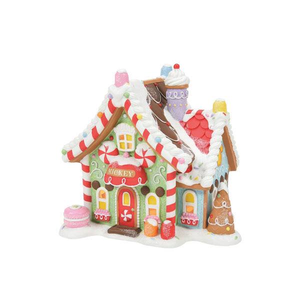 Mickey’s Peppermint Villa by Department 56 showcases a whimsical gingerbread house with Mickey on the door, pastel colors, candy embellishments, a snowy roof, candy canes, gumdrops, cupcakes, and a chocolate tree—all adorned with Disney favorites. Available for Pick-Up & Delivery.