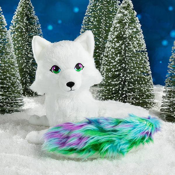 Noorah, an arctic fox plush toy with white fir and a green, blue and purple colored tail.