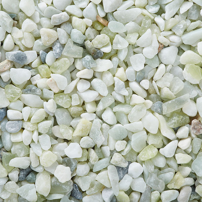 A close-up of Exotic Pebbles - Jade Bean Pebbles (5 lb.) in white, light green, grey, and beige shades by Available for Pickup & Delivery, tightly packed for a striking display.