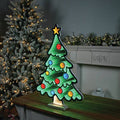 Christmas tree infinity light decoration lit up with a mantle and Christmas tree in the background.