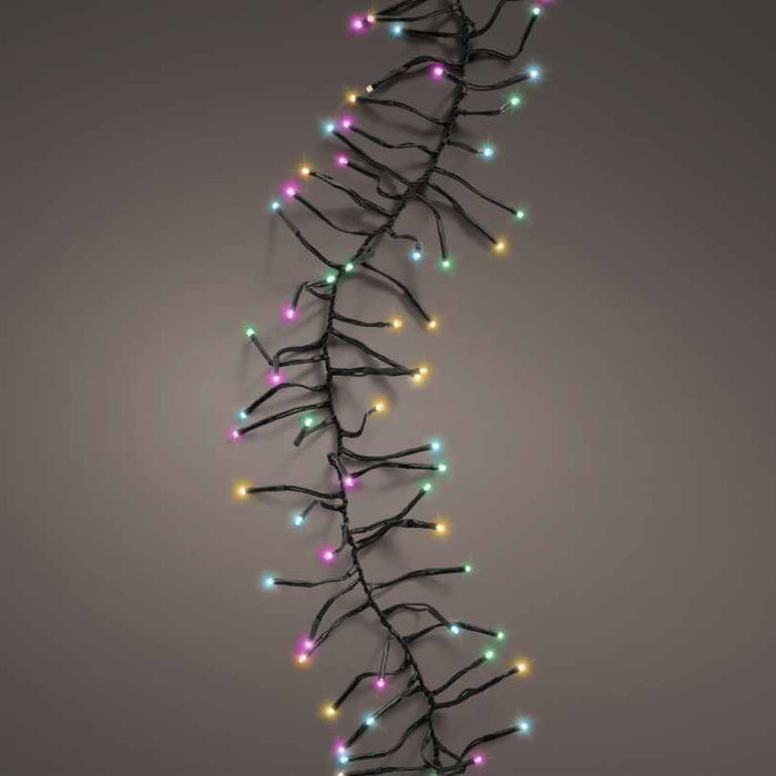 The LED Cluster Lights – Soft Multicolor – 8 Function by Available for Pick-Up & Delivery feature pink, yellow, green, and blue LEDs on a single strand, ideal for festive outdoor holiday displays against any backdrop.