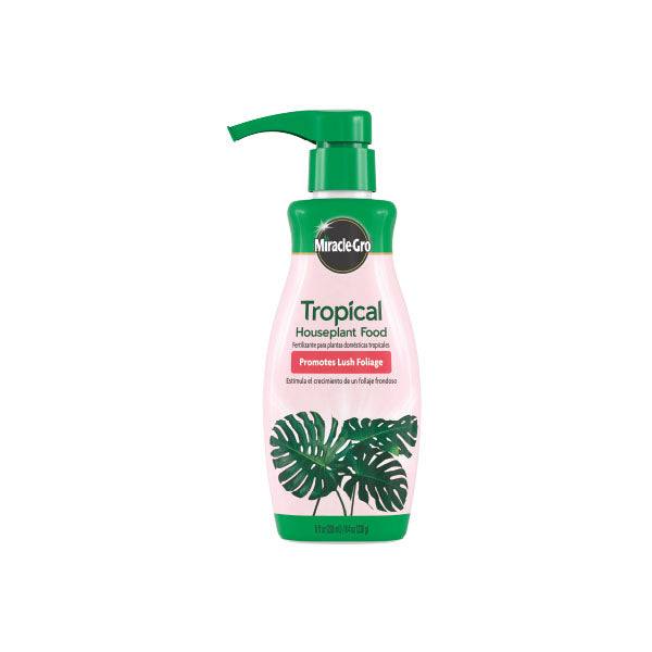 An 8 oz. pump bottle of Miracle Gro® Tropical Houseplant Food by All Delivery Options, featuring a green cap, pink label with green monstera leaves, and text promoting balanced nutrition for lush houseplant foliage.