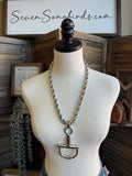Silver braided chain necklace on mannequin with snaffle bit pendant and ring