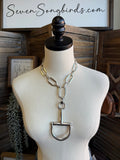 Silver-tone open-link necklace with long hanging U-shaped bit pendant on mannequin