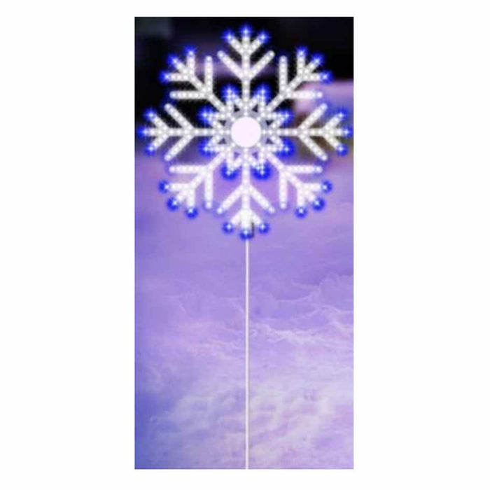 The Snowflake - LED Outdoor Decor - 24" from Available for Pick-Up & Delivery features twinkling blue and white lights on a slim pole, perfect for outdoor display against a purple, cloud-like backdrop.