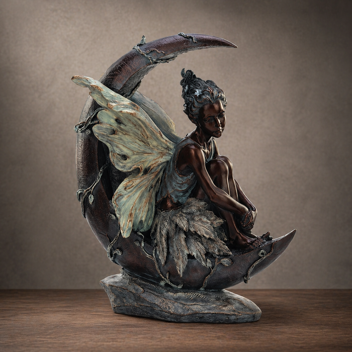 The Statuary - Fairy on a Crescent Moon by Pick-Up & Local Delivery Only is a bronze polyresin décor piece featuring a delicate-winged fairy sitting with knees up on a crescent moon, perfect for adding charm to your home.